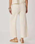 Person wearing cream-colored pants on a plain background