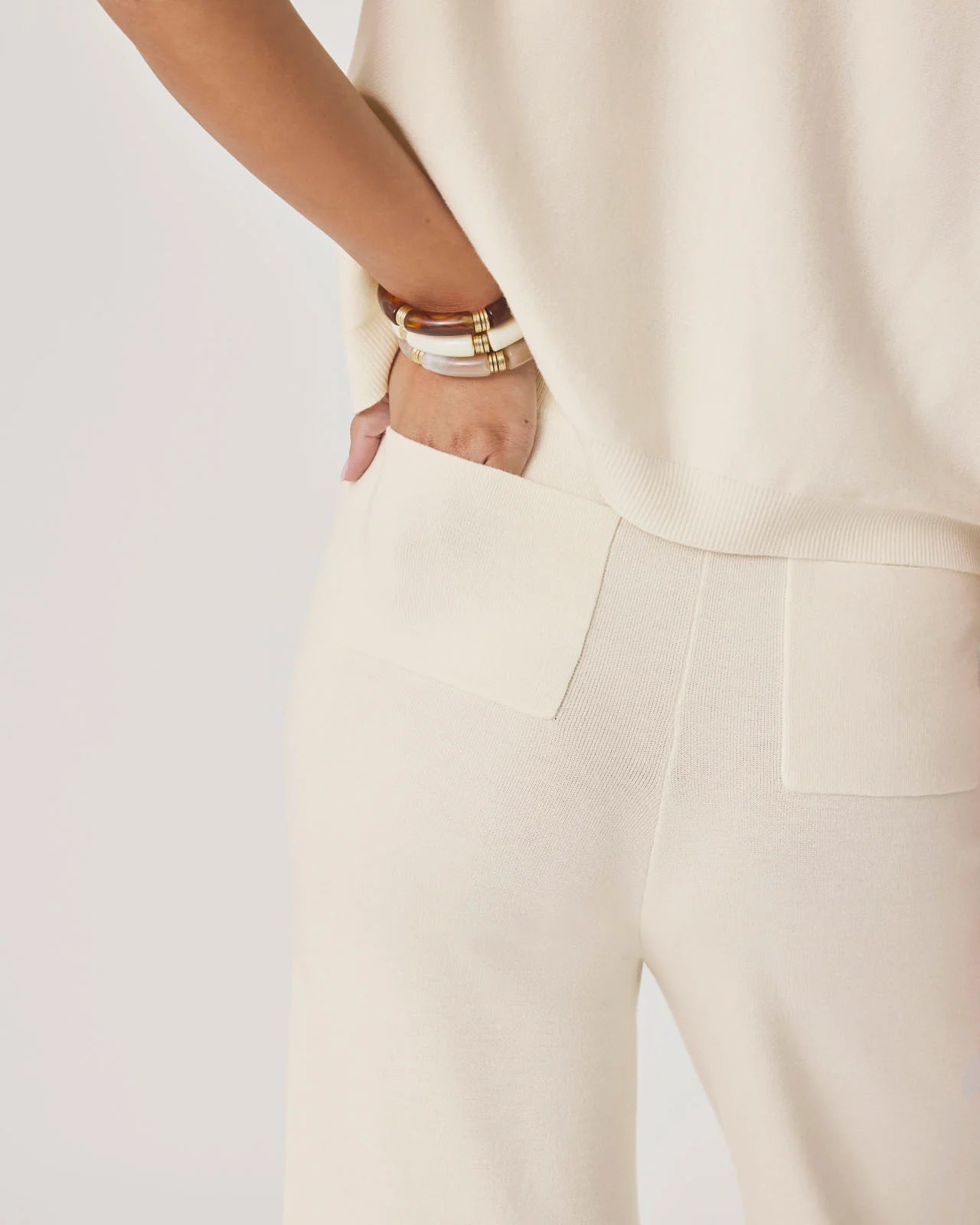 Person wearing a beige outfit with a blurred background