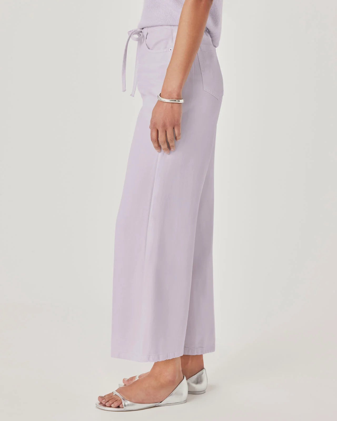 Person wearing light purple pants on a white background