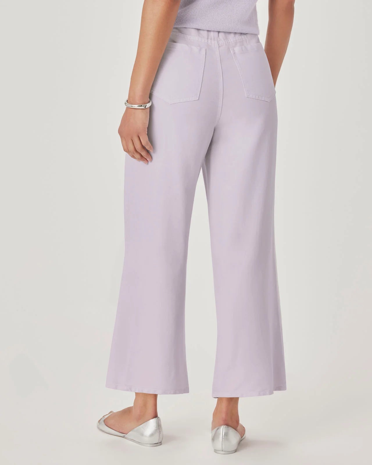 Person wearing light purple pants on a plain background