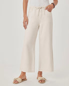 Person wearing white wide-leg pants on a plain background