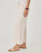 Person wearing white pants on a plain background