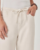 Close-up of beige pants with a drawstring on a white background