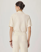 Woman wearing a beige outfit on a plain background