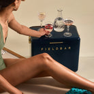 Woman in green dress sitting next to a Fieldbar cooler with drinks.