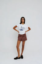 Woman wearing a white t-shirt with a graphic design on a plain background