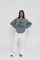 Person wearing a gray sweatshirt with a graphic design on a white background