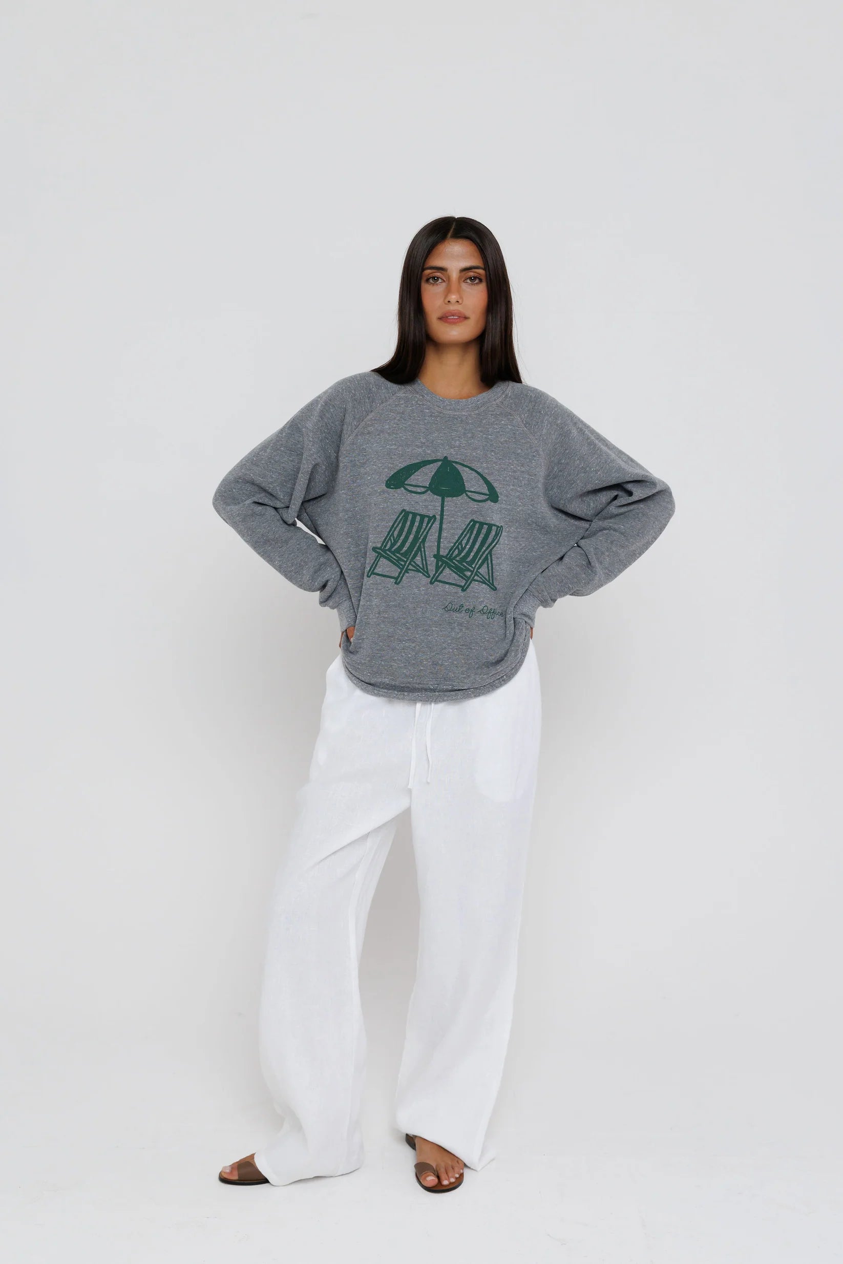Person wearing a gray sweatshirt with a graphic design on a white background