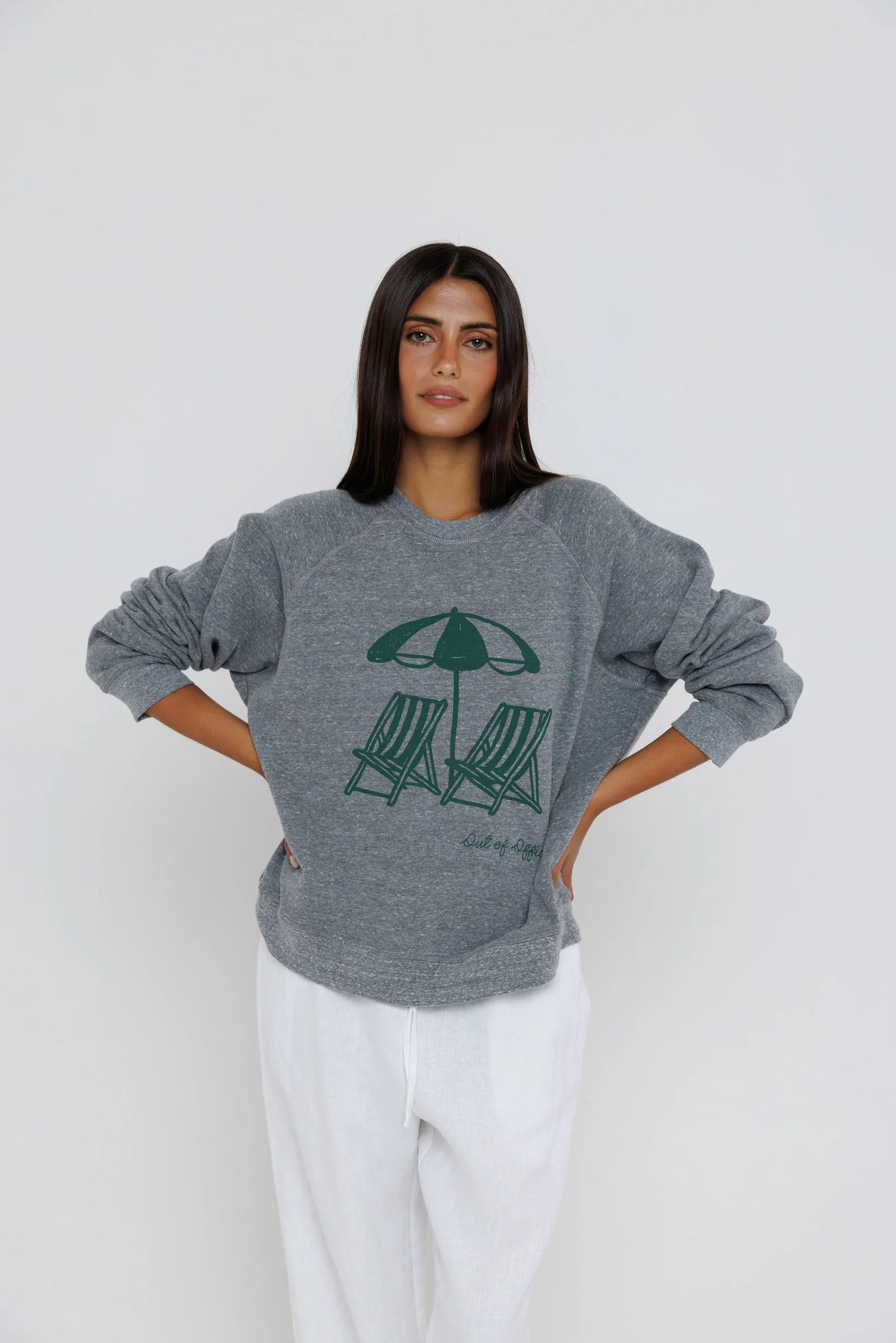 Woman wearing a gray sweatshirt with a graphic design on a white background