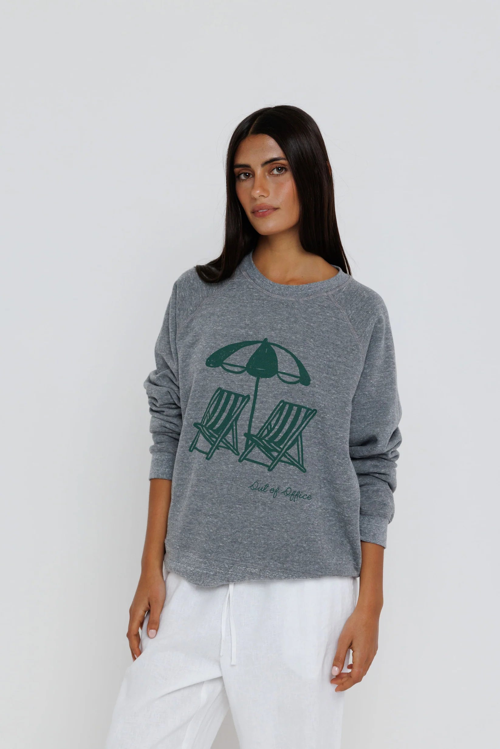 Woman wearing a gray sweater with a graphic design on a white background