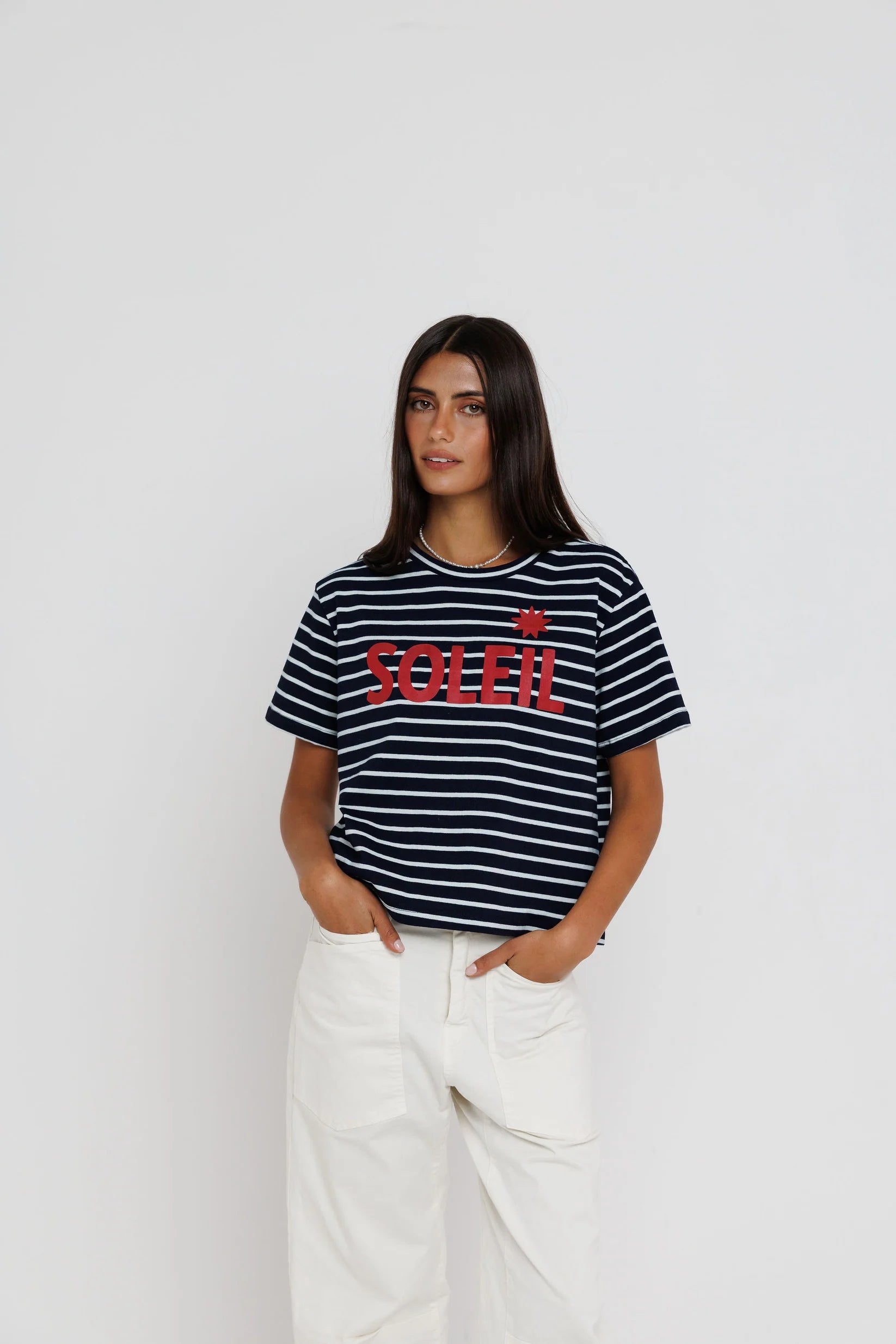 Woman wearing a black and white striped t-shirt with red text on a plain background