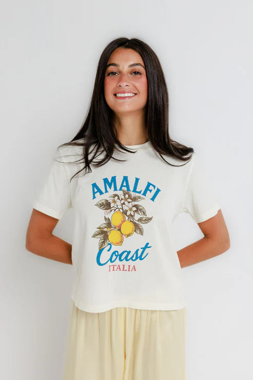 Woman wearing a white t-shirt with 'Amalfi Coast Italia' design on a plain background