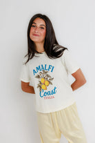 Woman wearing a 'Amalfi Coast Italia' t-shirt against a white background