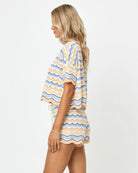 Woman wearing a colorful striped outfit on a white background