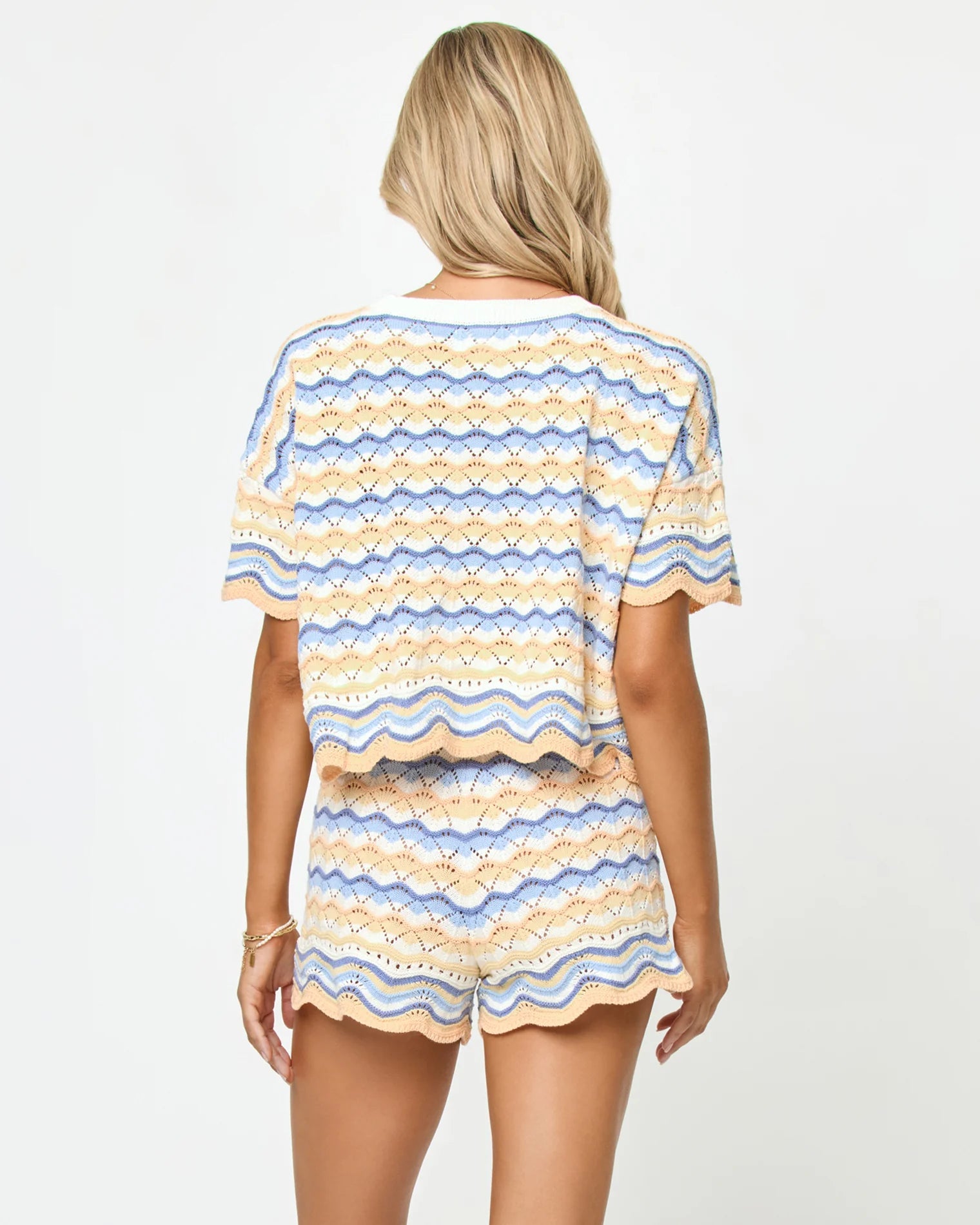 Woman wearing a colorful striped outfit on a plain background
