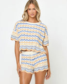 Woman wearing a matching top and shorts set with a wave pattern on a white background