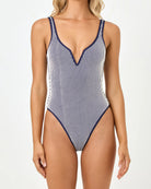 Woman wearing a blue and white striped swimsuit on a white background