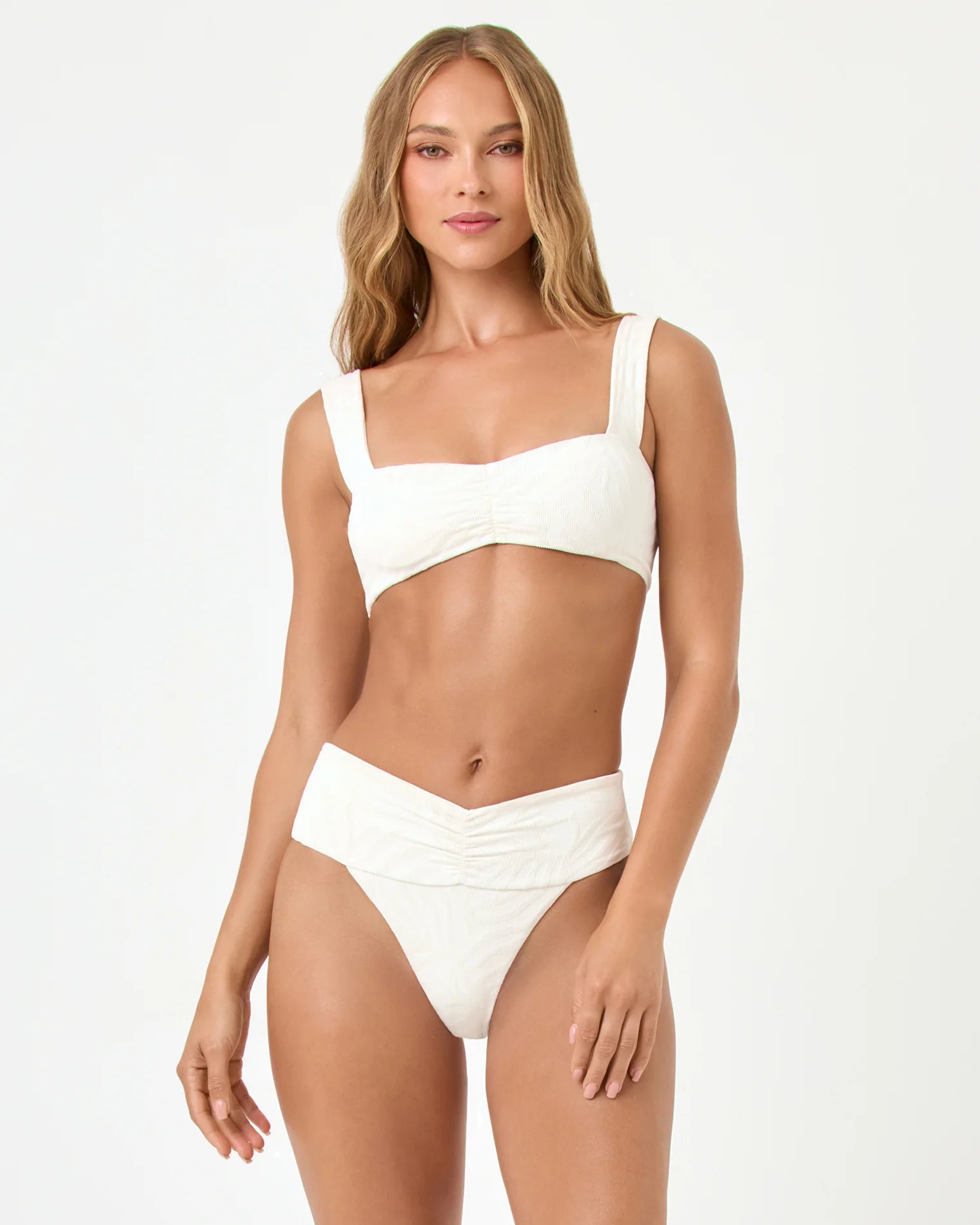 Woman wearing a white bikini on a plain background