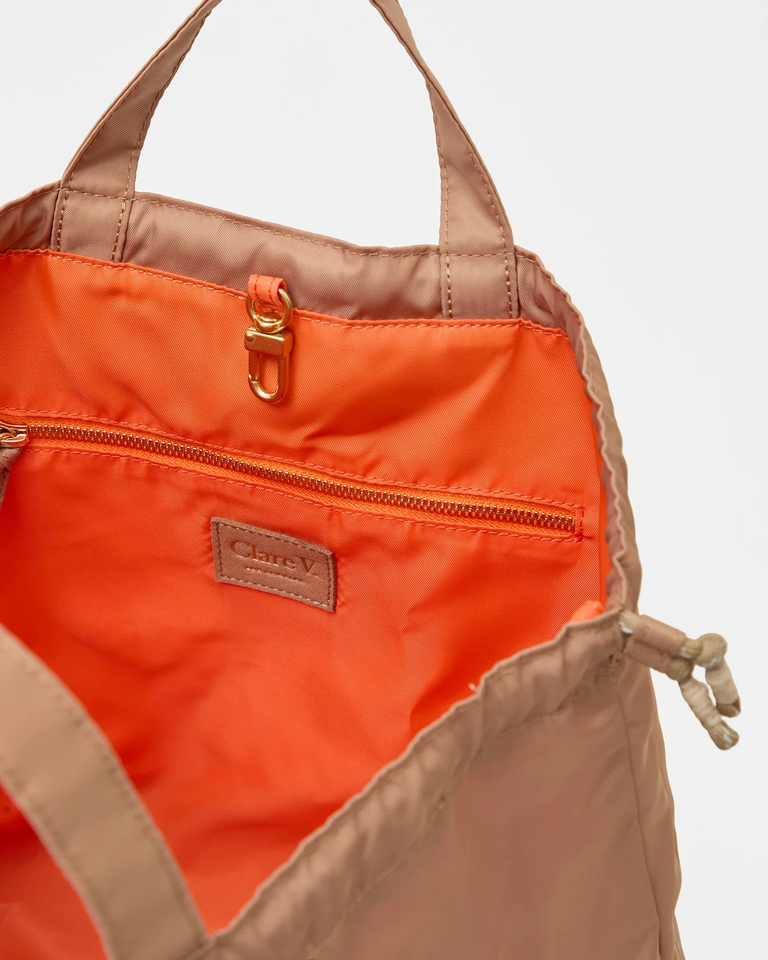 Orange and beige bag with a visible brand logo on a light gray background