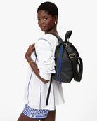 Woman wearing a black backpack with colorful drawstrings on a white background