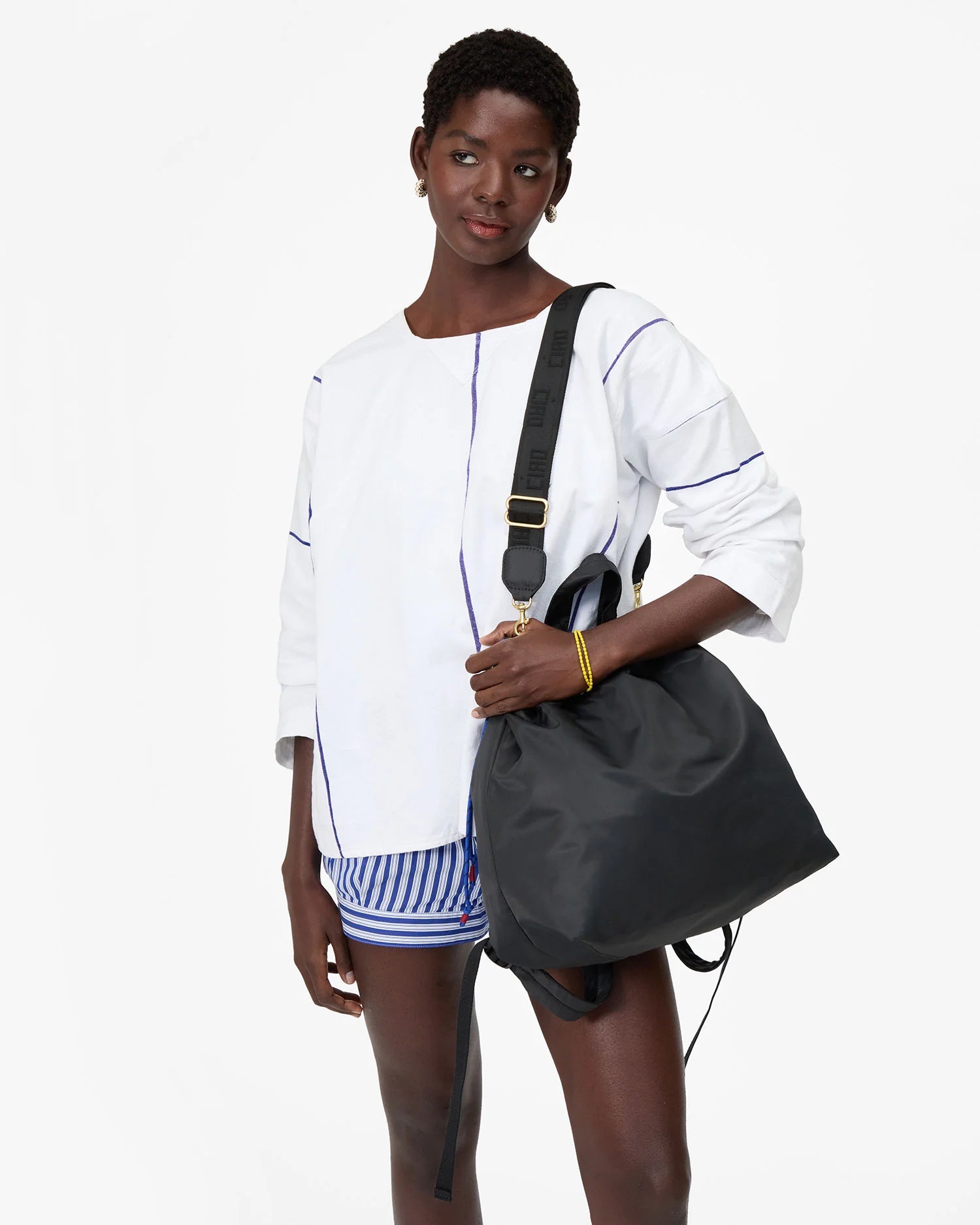 Woman holding a gray bag against a white background