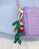 Colorful keychain with green spiral design attached to a purple textured bag.