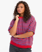 Woman wearing a red and blue striped sweater on a white background