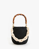 Black woven handbag with wooden handle and beige chain detail on a white background