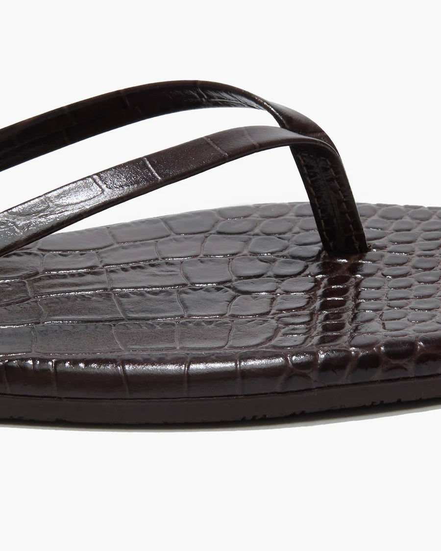 Brown sandal with crocodile texture sole on a white background