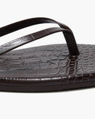 Brown sandal with crocodile texture sole on a white background