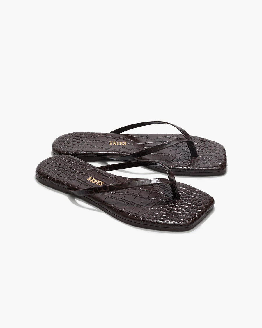 Pair of black flip-flops with a textured pattern on a white background