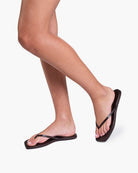 Person wearing black sandals on a white background