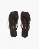 Pair of black flip-flops with 'TREES' branding on a white background