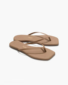 Pair of tan sandals on a white background