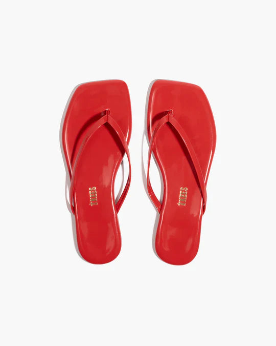 Pair of red flip-flops on a white background