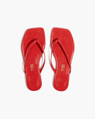 Pair of red flip-flops on a white background
