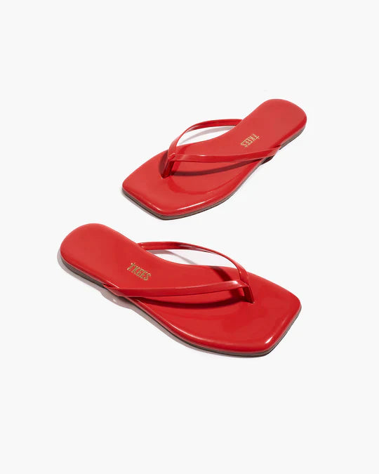 Pair of red flip-flops on a white background