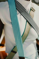 Close-up of a person wearing suspenders with a blurred background