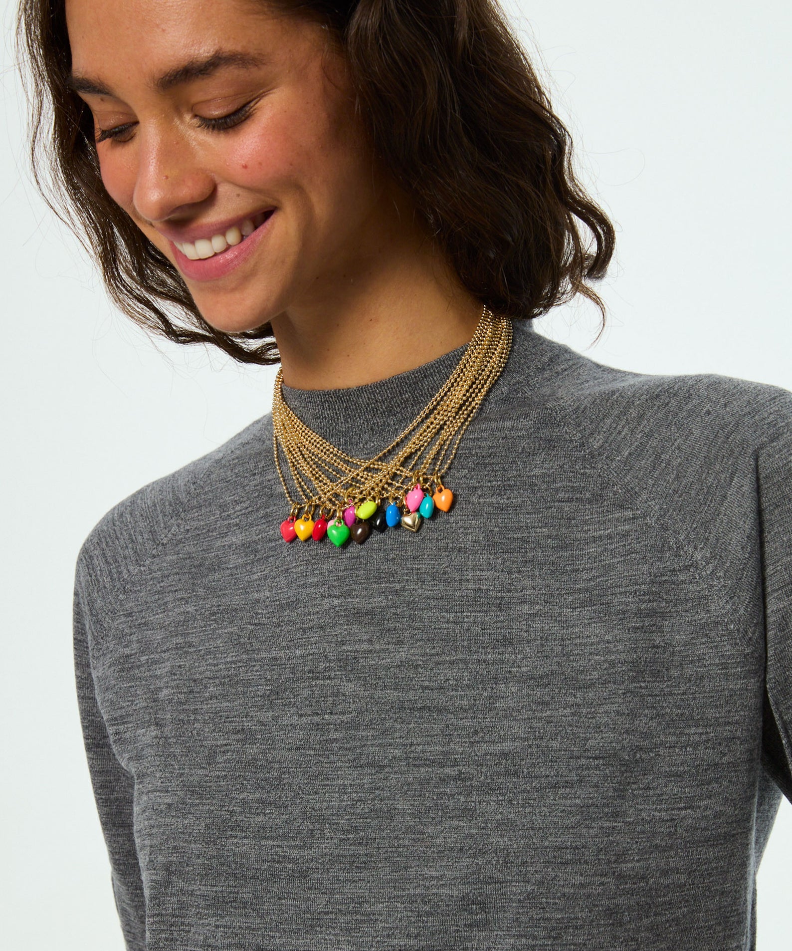 Woman wearing a colorful beaded necklace on a plain background