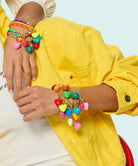 Person wearing colorful bracelets on a light blue background