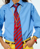 Person wearing a blue shirt, red striped tie, and yellow pants with accessories.