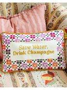 Embroidered pillow with 'Save Water, Drink Champagne' text on a floral background