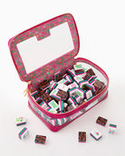 Pink floral-patterned jewelry case with small boxes of chocolates on a white background