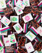 Collection of colorful game pieces with various designs on a white background