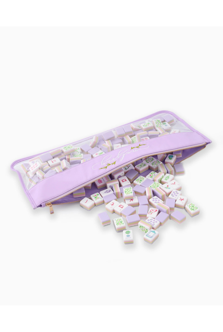 Set of pastel-colored dice with a purple carrying case on a white background