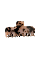 A tortoiseshell hair claw clip with a beige base and black mottled spots, shown against a plain white background.
