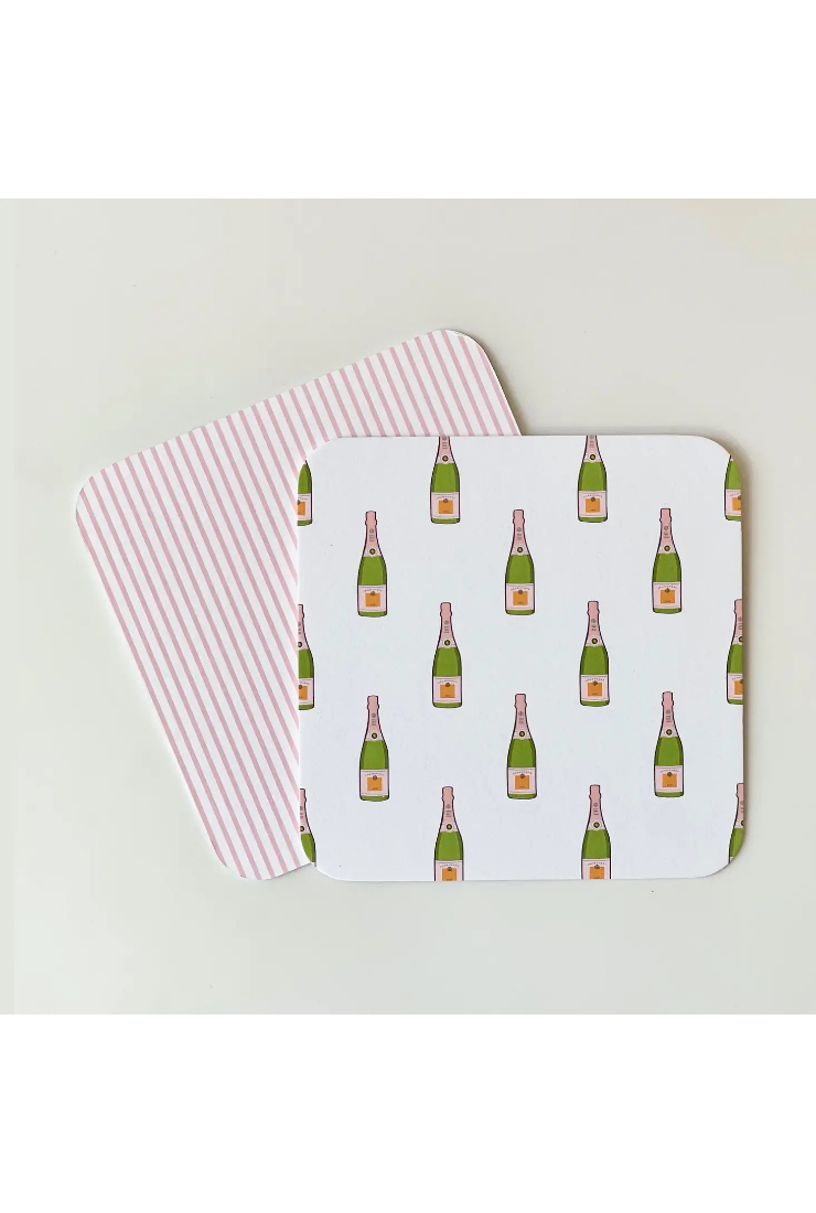Two placemats with champagne bottle pattern on a light background