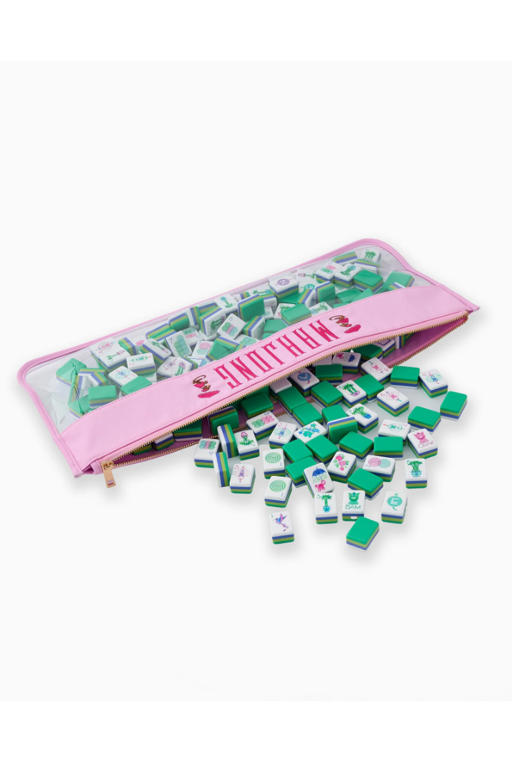 Green and white game pieces spilling out of a pink pouch labeled 'Snaggle Paws' on a white background.