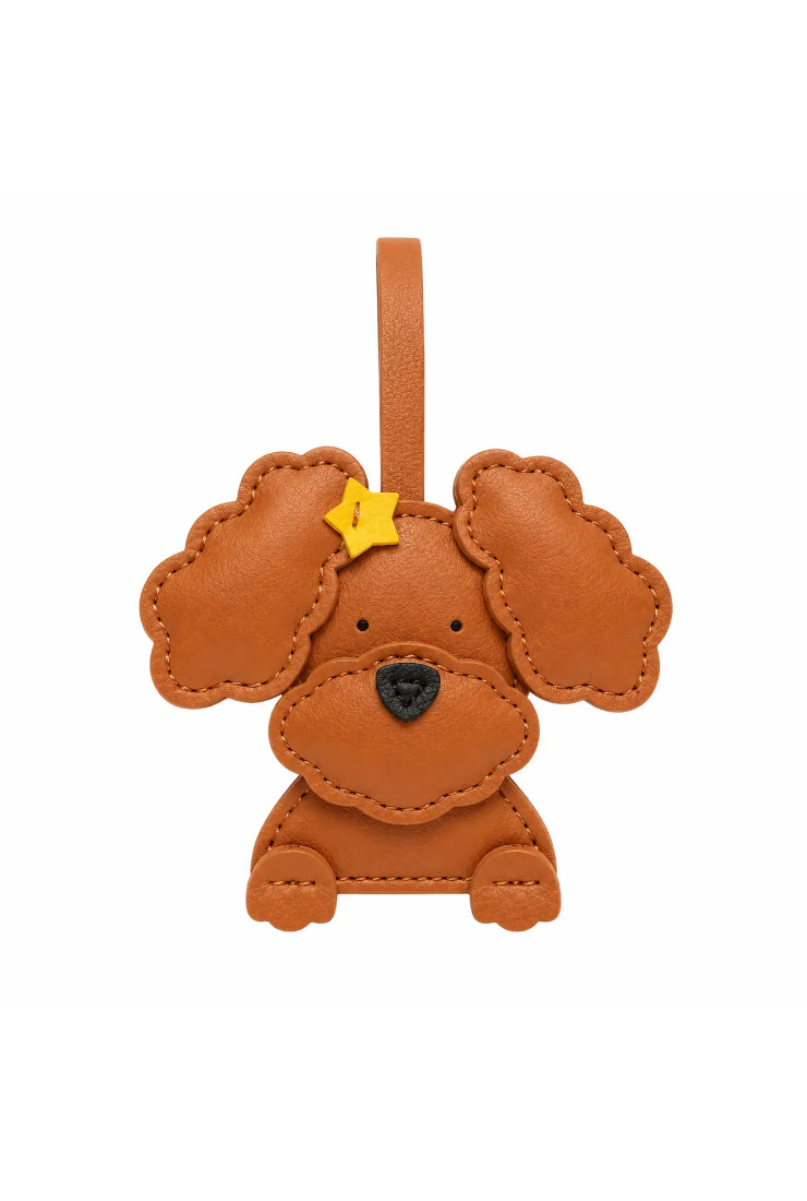 A brown leather poodle-shaped bag charm with a small yellow star on its forehead, shown against a plain white background.