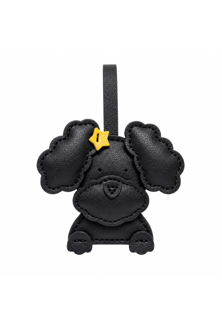 A black leather poodle-shaped car keychain charm with a small yellow star accessory on its ear, shown against a plain white background.
